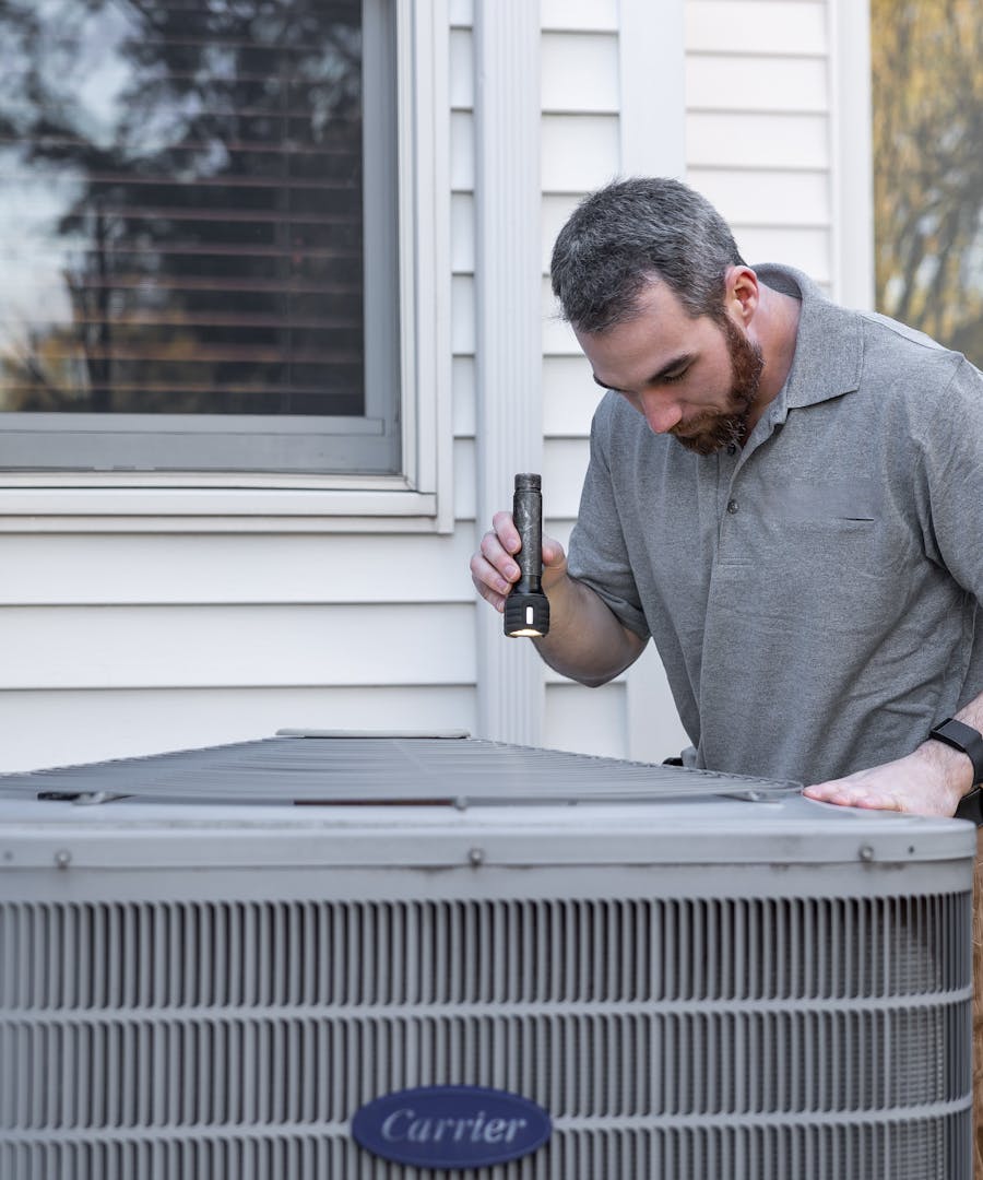 A Brennan & Sons technician servicing a home HVAC system